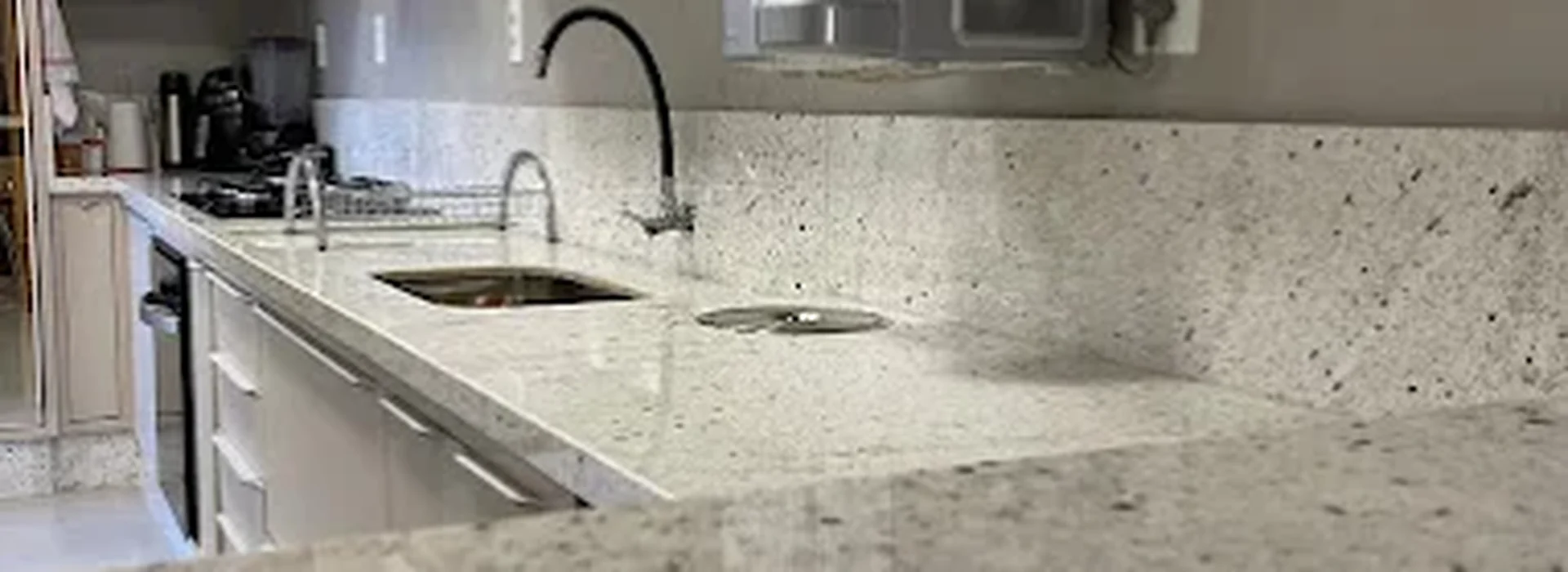 Bancada de cozinha em granito claro com veios e cuba embutida